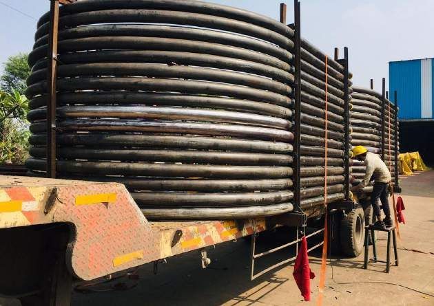 Coiled pipes secured on trailer